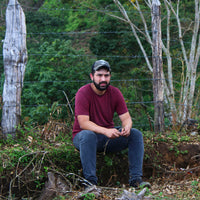 Benjamín Paz Muñoz sitting at his farm La Orquidea in Santa Barbara, Honduras